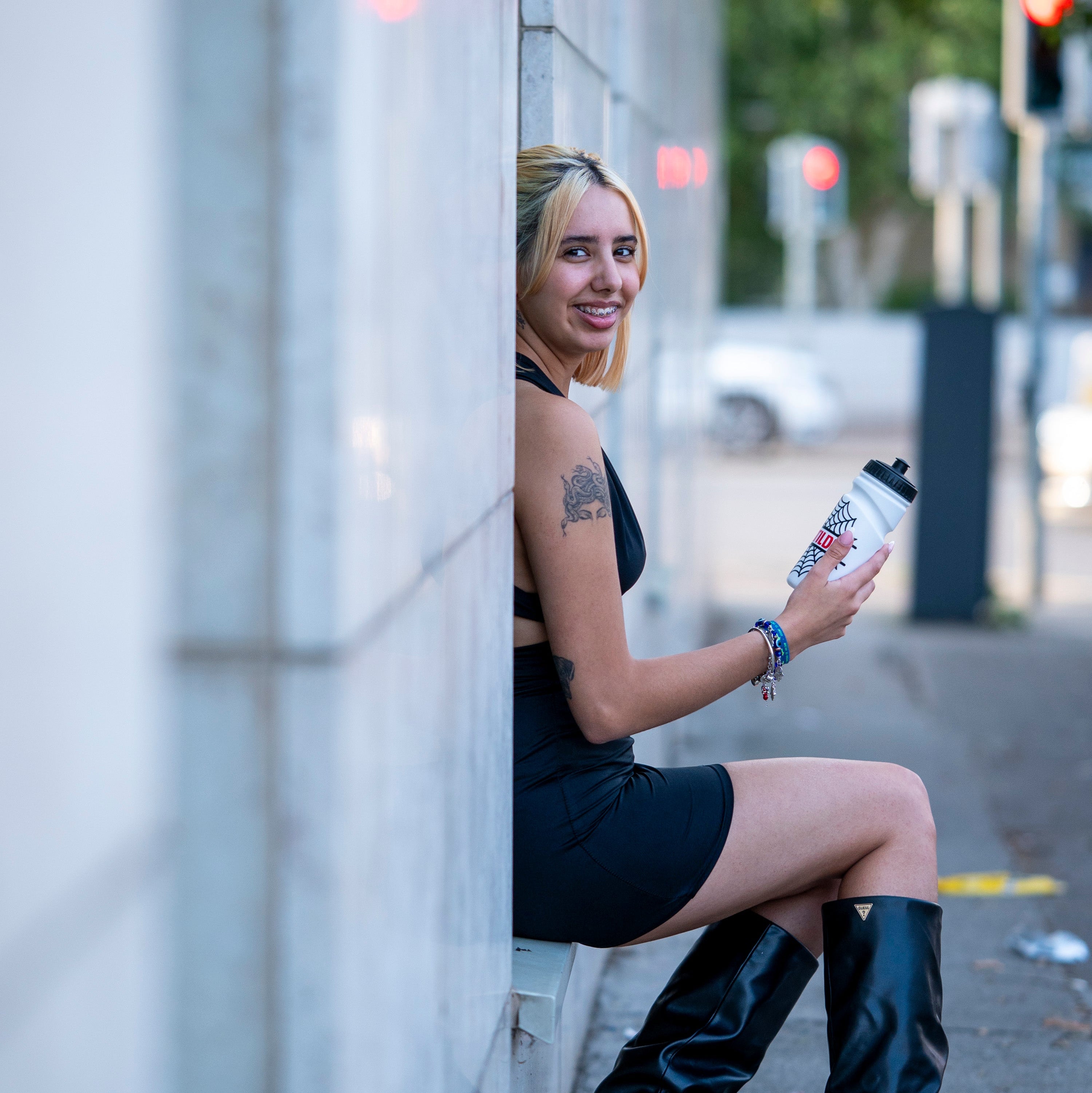 Woman holding a water bottle on a city street